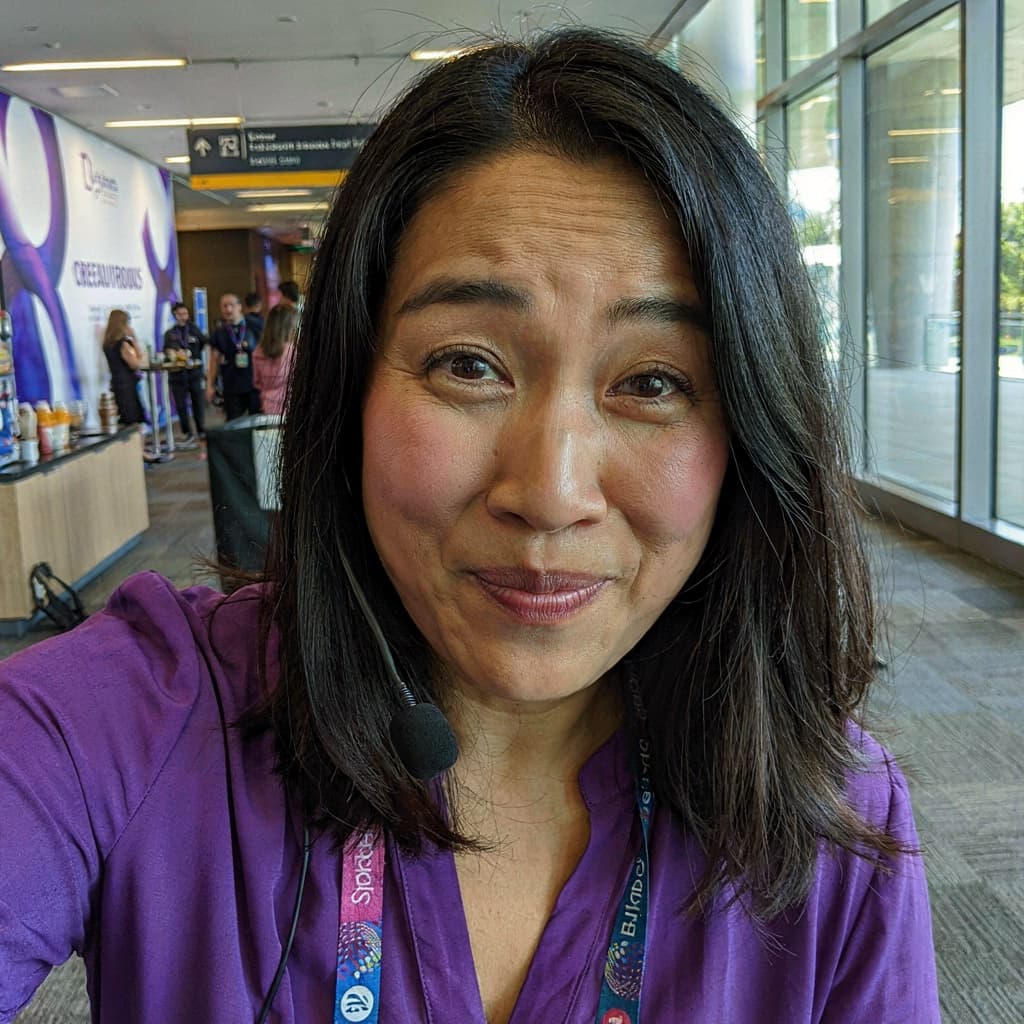 Conference hallway selfie of a female keynote speaker before headshot generation